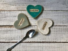 three ceramic heart shaped spoons with coffee written on them