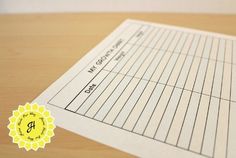 a close up of a piece of paper on a wooden table with a yellow seal