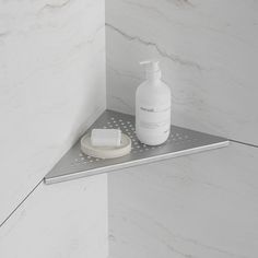 a bottle of lotion sitting on top of a shelf next to a soap dispenser