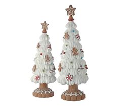 two white ceramic christmas trees with decorations on them