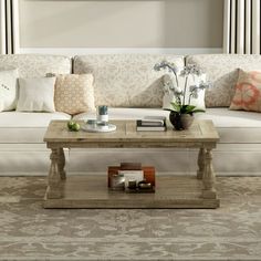 a living room filled with furniture and flowers on top of a coffee table in front of a window