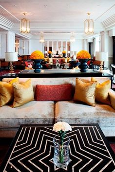 a living room filled with lots of furniture and flowers on top of a coffee table