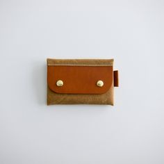 A simple, practical, beautiful, minimal slim wallet. FEATURES : -premium English Bridle veg-tanned leather -easy open solid brass spring snap closure -one interior divider MEASUREMENT : height : 2.75 inches width : 4.25 inches - 0.25 inches) ABOUT THE FABRIC : exterior : 10.10 oz water resistant / waxed canvas interior : cotton/polyester Gold Trifold Wallet With Card Slots For Everyday Use, Modern Gold Wallet, Modern Gold Wallets, Everyday Rectangular Trifold Wallet With Snap Closure, Rectangular Card Holder With Snap Closure, Everyday Rectangular Card Holder With Snap Closure, Minimalist Everyday Wallet With Coin Pocket, Gold Bifold Wallet For Everyday Use, Gold Card Holder For Everyday Use