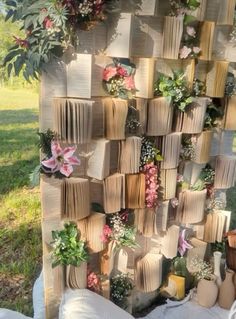 an outdoor display with books, flowers and plants on the outside wall is made out of old book pages