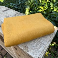 a yellow blanket sitting on top of a wooden bench