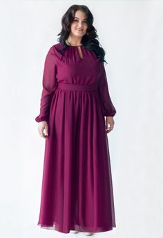 a woman in a purple dress posing for the camera with her hands on her hips