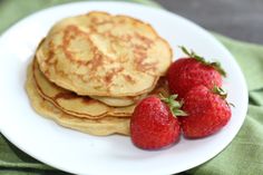 some pancakes and strawberries on a white plate