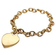 A very fine Tiffany & Co. bracelet. In 18k gold. With slightly oval links and a heart-shaped pendant charm. The charm is not engraved. Simply wonderful, classic Tiffany design! Date: 20th Century Overall Condition: It is in overall good, as-pictured, used estate condition with some very fine & light surface scratches and other signs of expected light wear consistent with age. Fineness: Marked 750 for 18k gold fineness. Marks: Tiffany & Co. / 750 Measurements: Length: ca. 7 1/2 in Pendant Width: Tiffany Lock Gold Bracelet, Classic White Gold Charm Bracelet With Heart, Classic White Gold Charm Bracelet With Heart Charm, Luxury Yellow Gold Bracelet With Heart Charm, Luxury Yellow Gold Heart Charm Bracelet, Luxury Yellow Gold Heart Bracelet With Charm, Luxury Yellow Gold Heart Bracelet With Heart Charm, Luxury Yellow Gold Heart-shaped Bracelet, Classic Heart Charm Bracelet