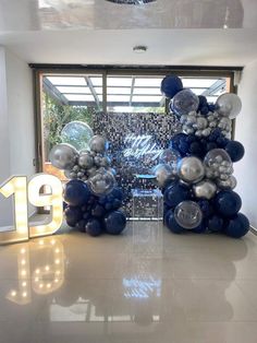 the entrance to an office decorated with balloons and streamers in blue and silver colors