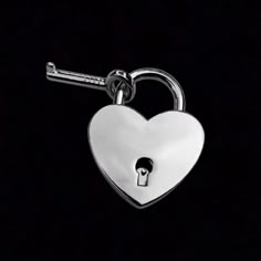 a heart shaped keychain with a lock on the front and back side, against a black background