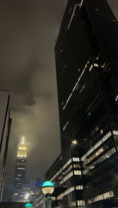 the city is lit up at night with skyscrapers in the backgrounnd