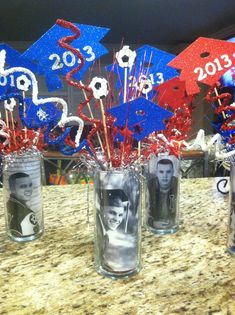 two vases filled with red, white and blue streamers on top of a table