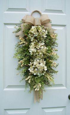 a door with a wreath and flowers hanging on it