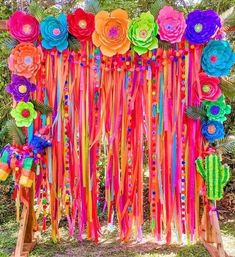 colorful paper flowers and streamers decorate an outdoor ceremony