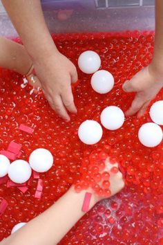 two children playing with red and white beads