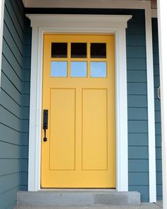 a yellow front door on a blue house