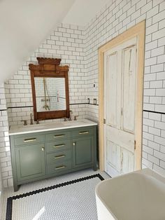 a bathroom with green cabinets and white tiles on the floor, along with a bathtub