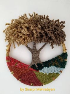 a knitted tree ornament with four different colors and sizes on it, in front of a white background