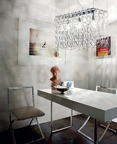 a dining room table and chairs with a chandelier hanging from the ceiling