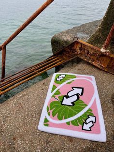 a towel is laying on the ground next to some water and a rusted rail