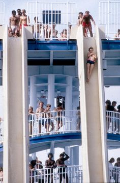 several people are standing on the balcony of a cruise ship while others watch from their balconies