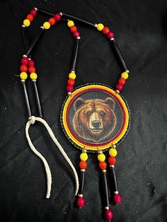 Size 10 seed beads and the center is a patch. Medallion is 4x4" Beaded lanyards is 28"  total length and does not untie simply slips over your head ARTIST NAME: Aodhàn Crawford TRIBAL AFFILIATION: Cherokee Your item comes with Certificate of Native American Made/Celtic Made Authenticity Handmade Adjustable Medallion Necklace, Adjustable Medallion Beaded Necklaces For Festivals, Artisan Multicolor Medallion Beaded Necklaces, Artisan Multicolor Medallion Beaded Necklace, Bear Medallion, Diy Jewelry Unique, Beaded Lanyards, Tacoma Wa, Jewelry Unique