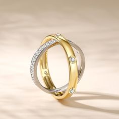 two tone gold and silver wedding ring with diamonds on the sides, set against a plain background