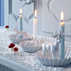 some white candles are sitting on a table