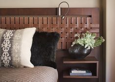 a wooden headboard with pillows and a vase on it