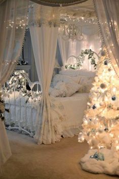 a bedroom decorated for christmas with white decorations and lights on the bed, trees in the corner