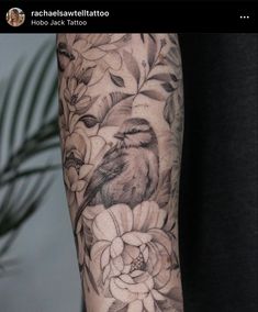 a woman's arm with flowers and a bird on it