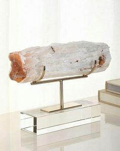 a large piece of wood sitting on top of a white table next to a book