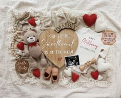 a baby announcement with teddy bears and other items on a white blanket that says our little sweetheart is on the way