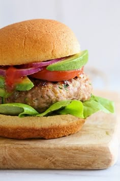 a hamburger with lettuce, tomato and onion