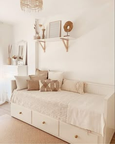 a white daybed with pillows on it in a room