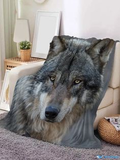 a grey wolf pillow sitting on top of a bed