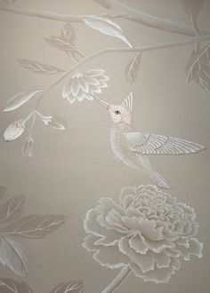 a white bird sitting on top of a flower covered wall