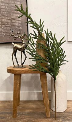 a wooden table topped with a plant next to a deer figurine on top of it