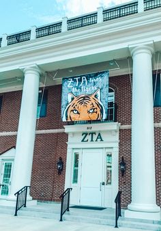 a large building with columns and a tiger sign on it's front entrance door