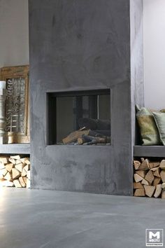 a fire place sitting next to a pile of wood