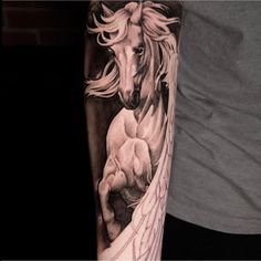 a man's arm with a horse and wings tattoo on the left side of his arm