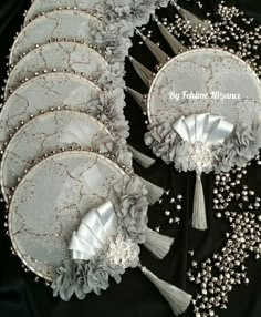 several silver flowers and tassels on a black table cloth with the words, my wedding treasures