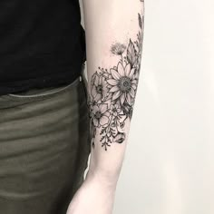 a woman with a black and white tattoo on her arm holding onto a flower bouquet