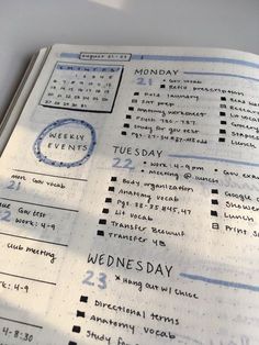 a close up of a planner on a table with the words wednesday written in blue ink