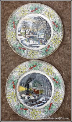 two plates with paintings on them sitting next to each other in front of a brown background