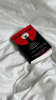 a book sitting on top of a white bed covered in sheets and pillows with the title nympwnn