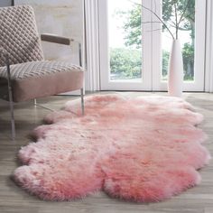 a pink rug is on the floor next to a chair