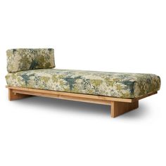 a green and white couch sitting on top of a wooden frame