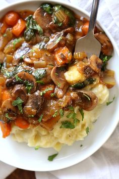 a white plate topped with mashed potatoes and mushrooms