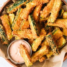 fried zucchini sticks with dipping sauce in a bowl